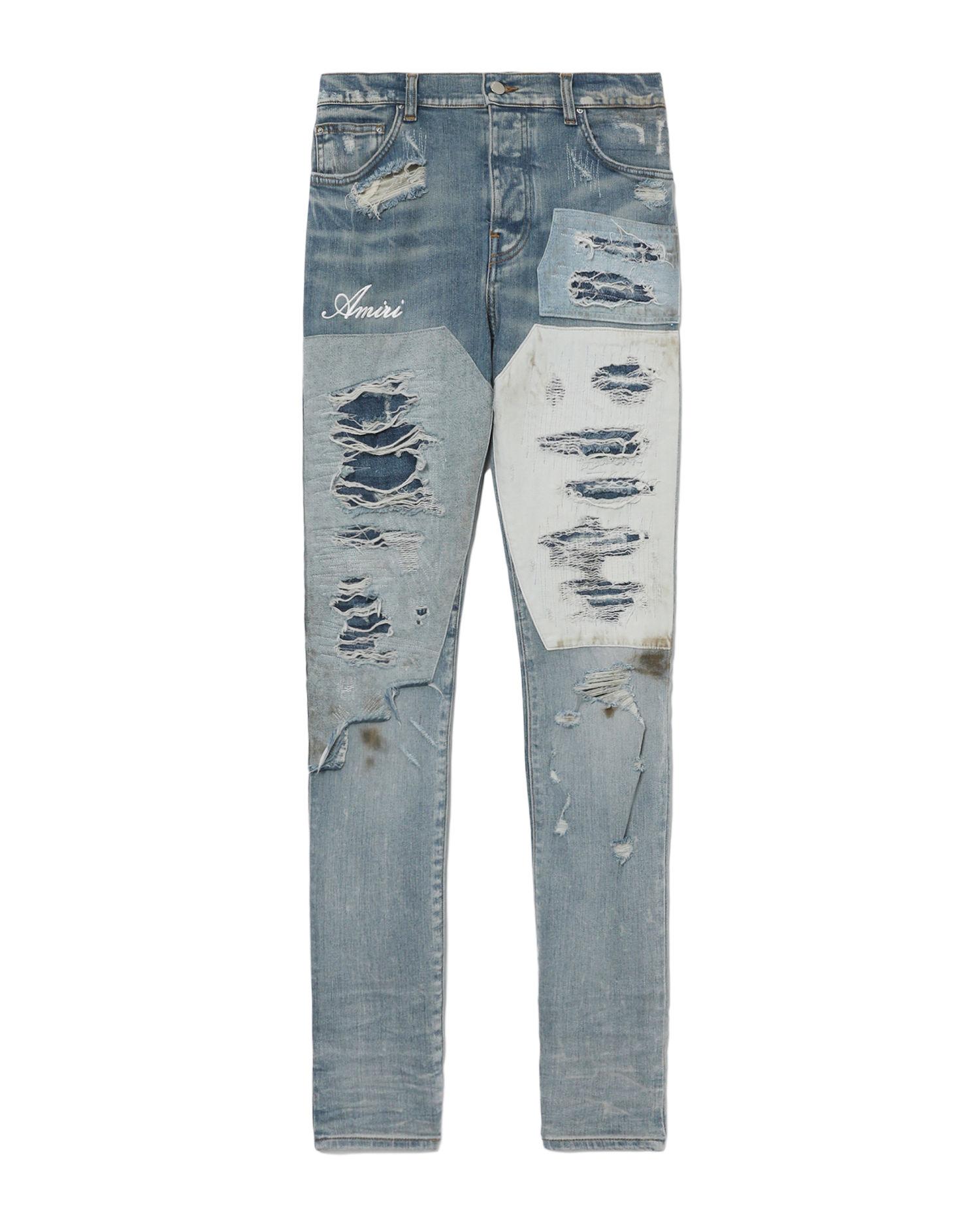 Distressed patchwork denim jeans by AMIRI