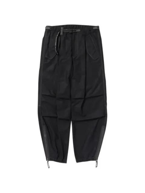 contrast-stitch belted trousers by AND WANDER
