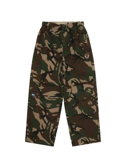 AAPEUNVS moonface camo-print trousers by BAPE