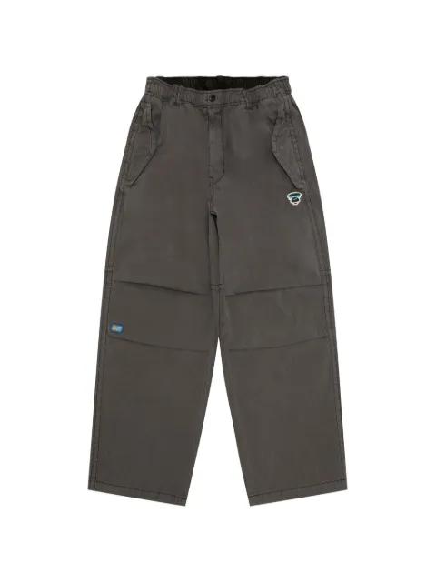 Moonface logo-patch trousers by BAPE
