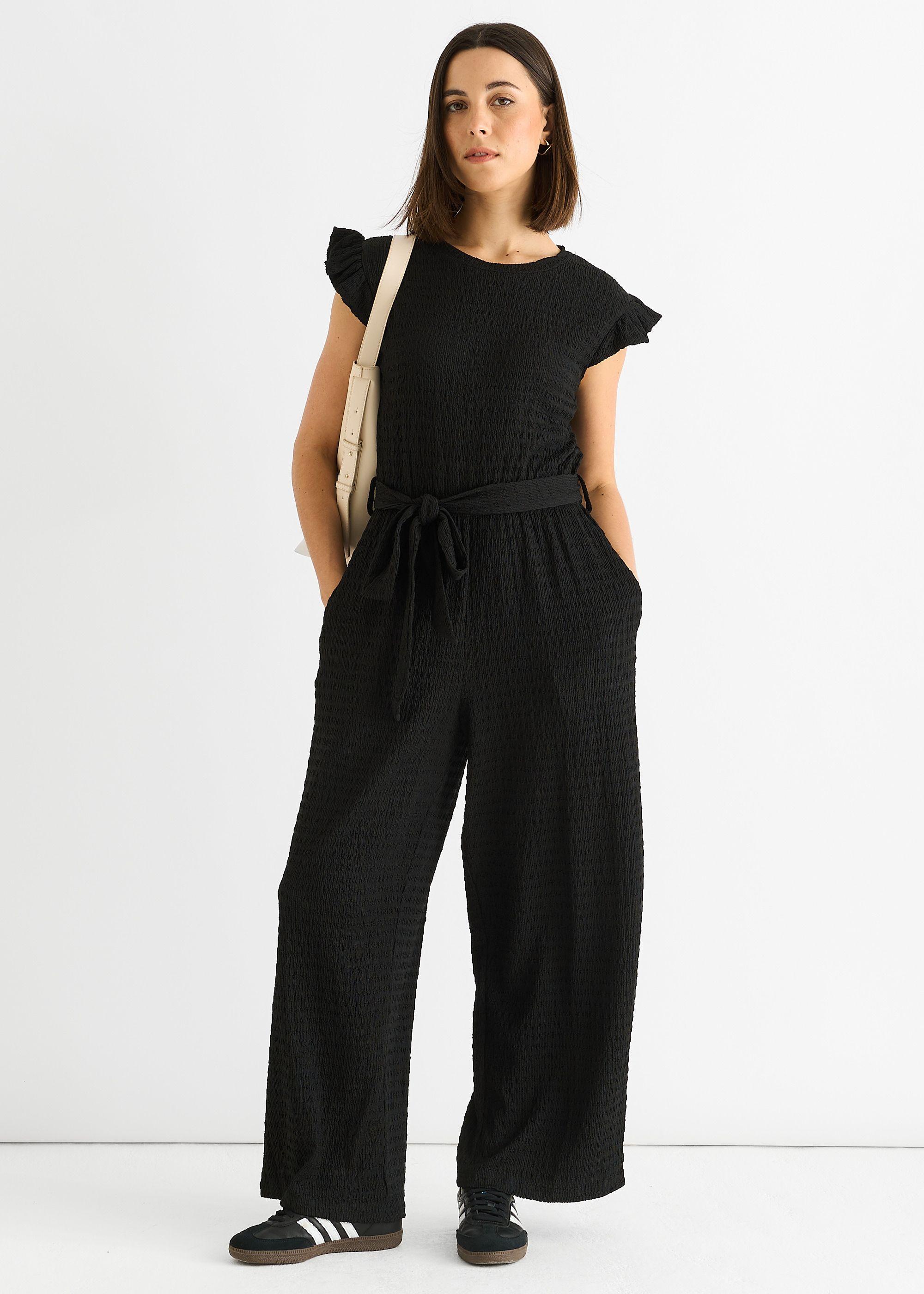 Black Stretch Texture Frill Elasticated Waist Jumpsuit by GINI LONDON