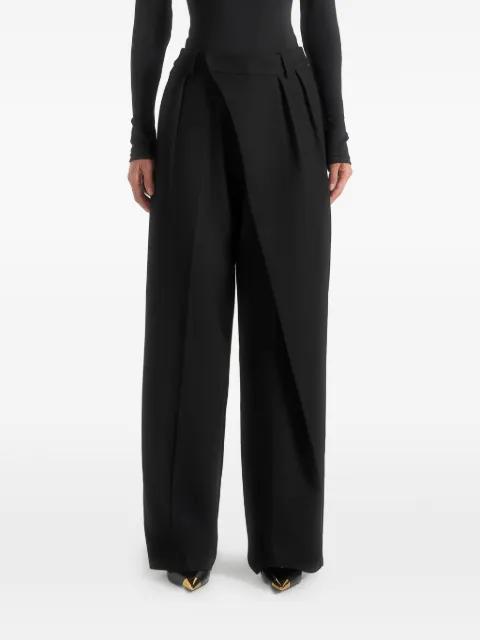 Colette in black tailored wrap pleat trousers by MANIERE DE VOIR