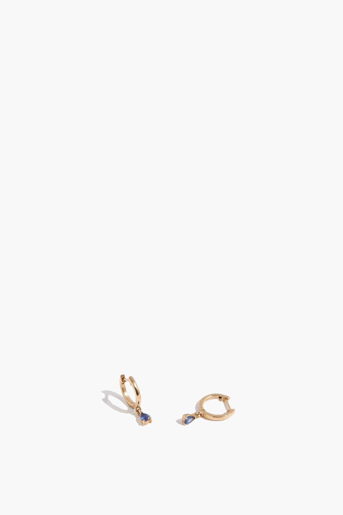 Blue Sapphire Drop Huggies in 14k Yellow Gold by THEODOSIA