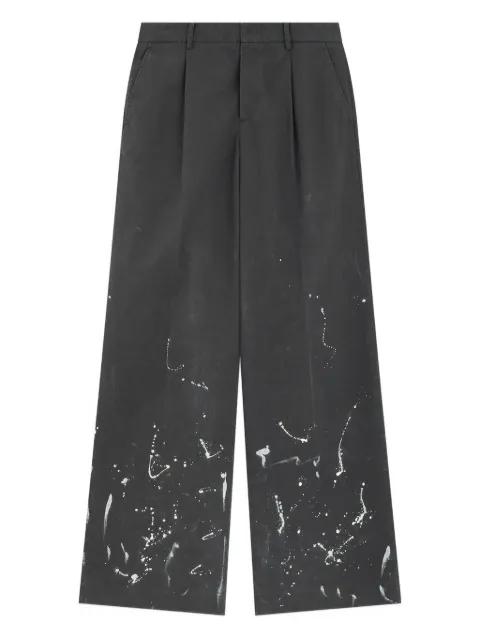 pleated paint-splatter trousers by WE11DONE